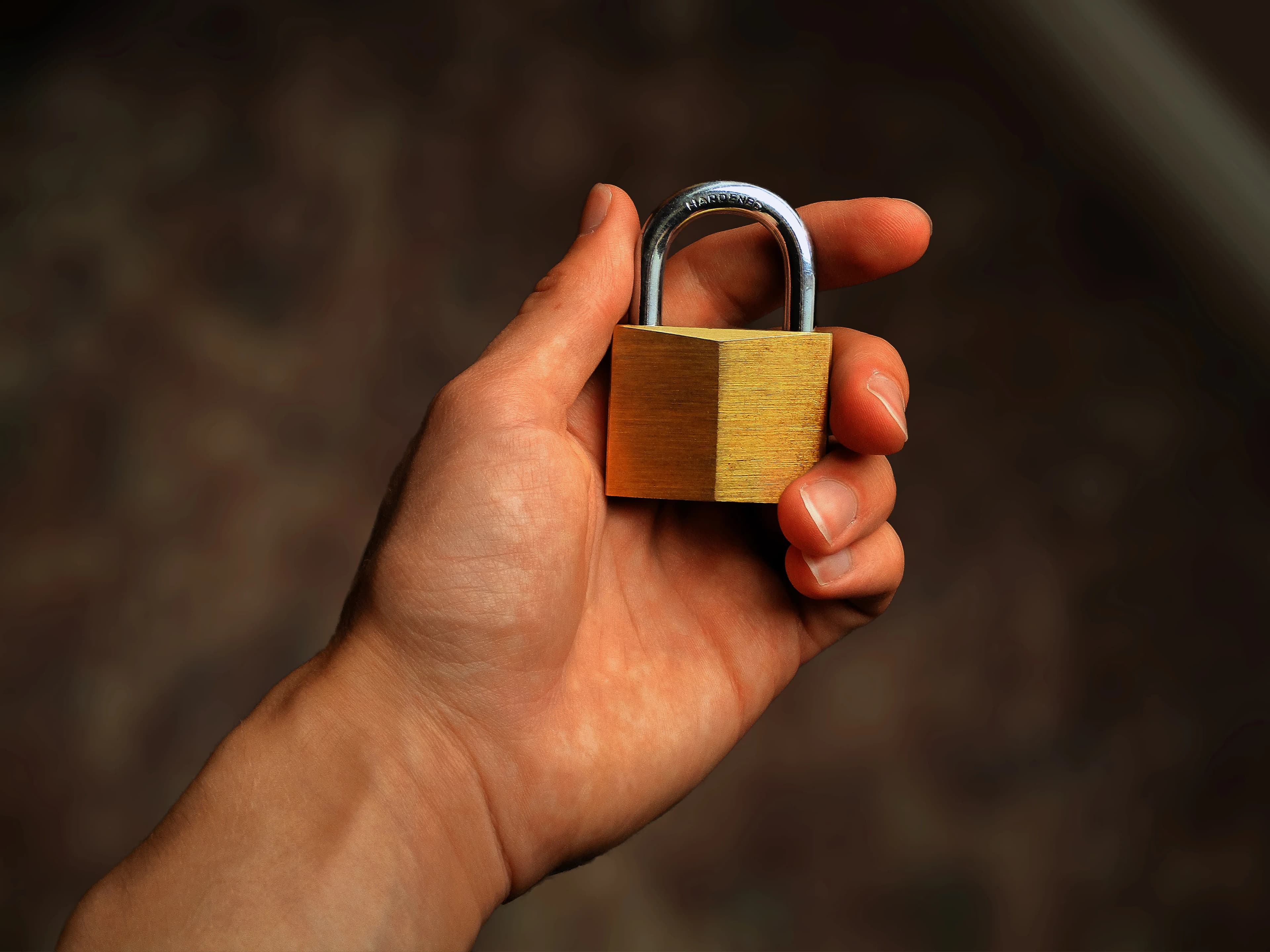 A close-up of a hand holding a secure padlock.