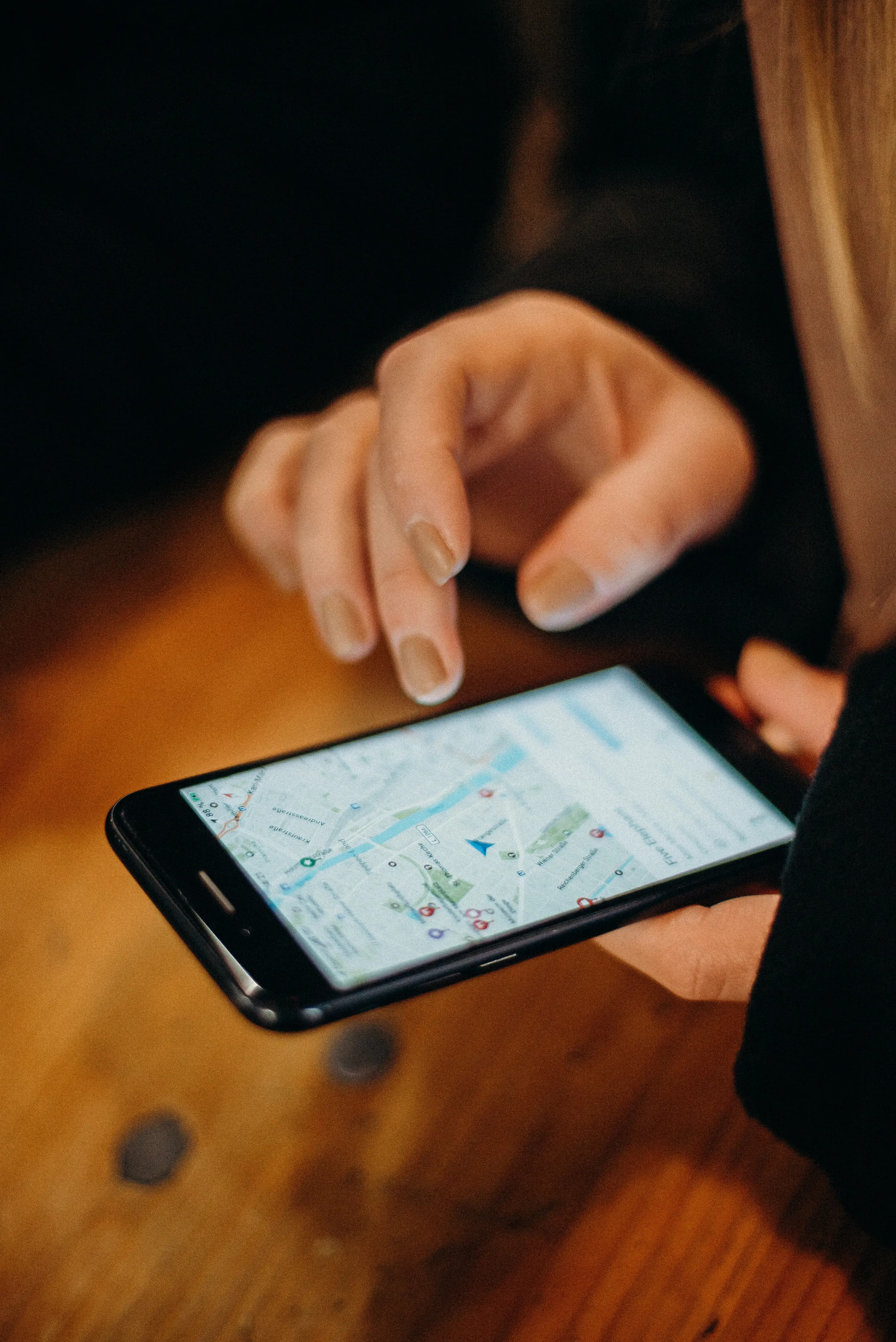 A hand tapping a map on a smartphone screen.
