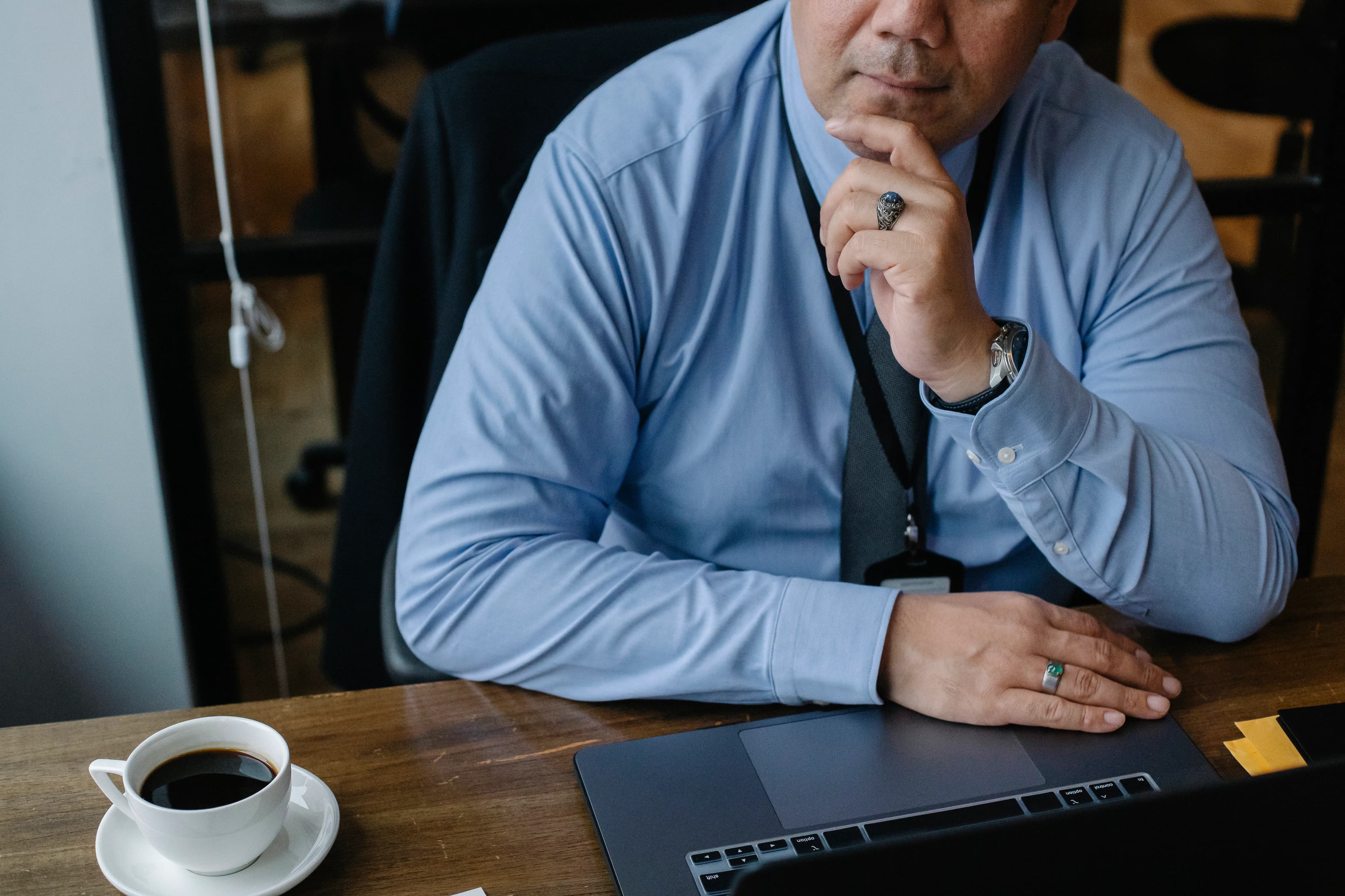 A business owner seated at a desk with a laptop and a cup of coffee.