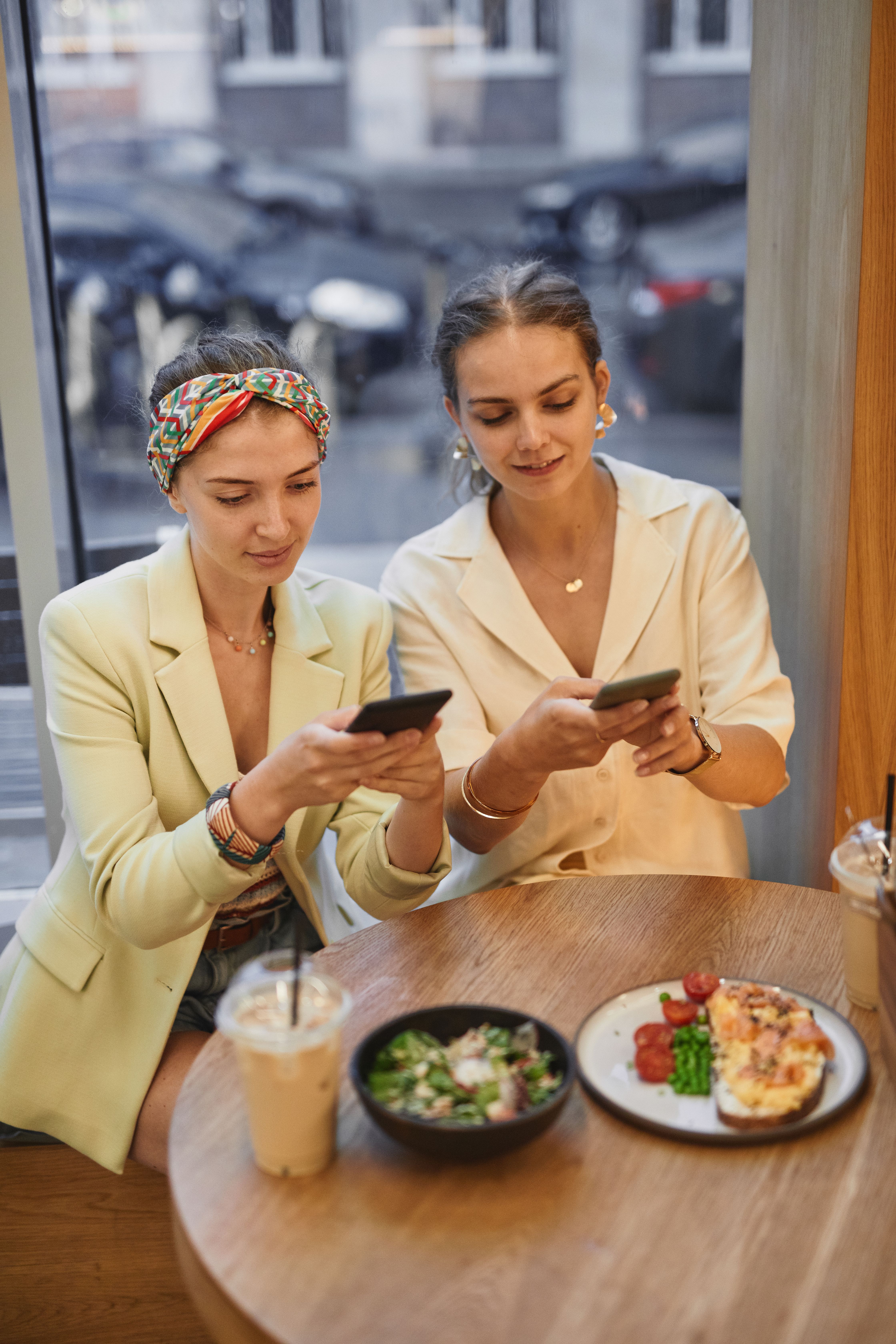 Two women using a smartphone to browse a business website, illustrating mobile-first customer behaviour